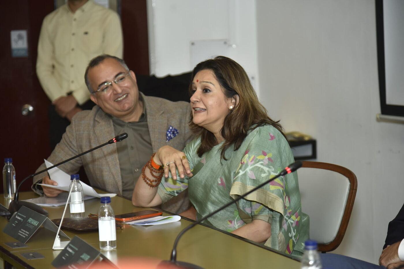 Priyanka Chaturvedi speaking animatedly, the panellist beside her laughing