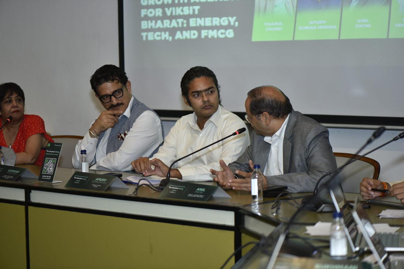 Anil Patni turning to address his long-haired co-panellist across the table