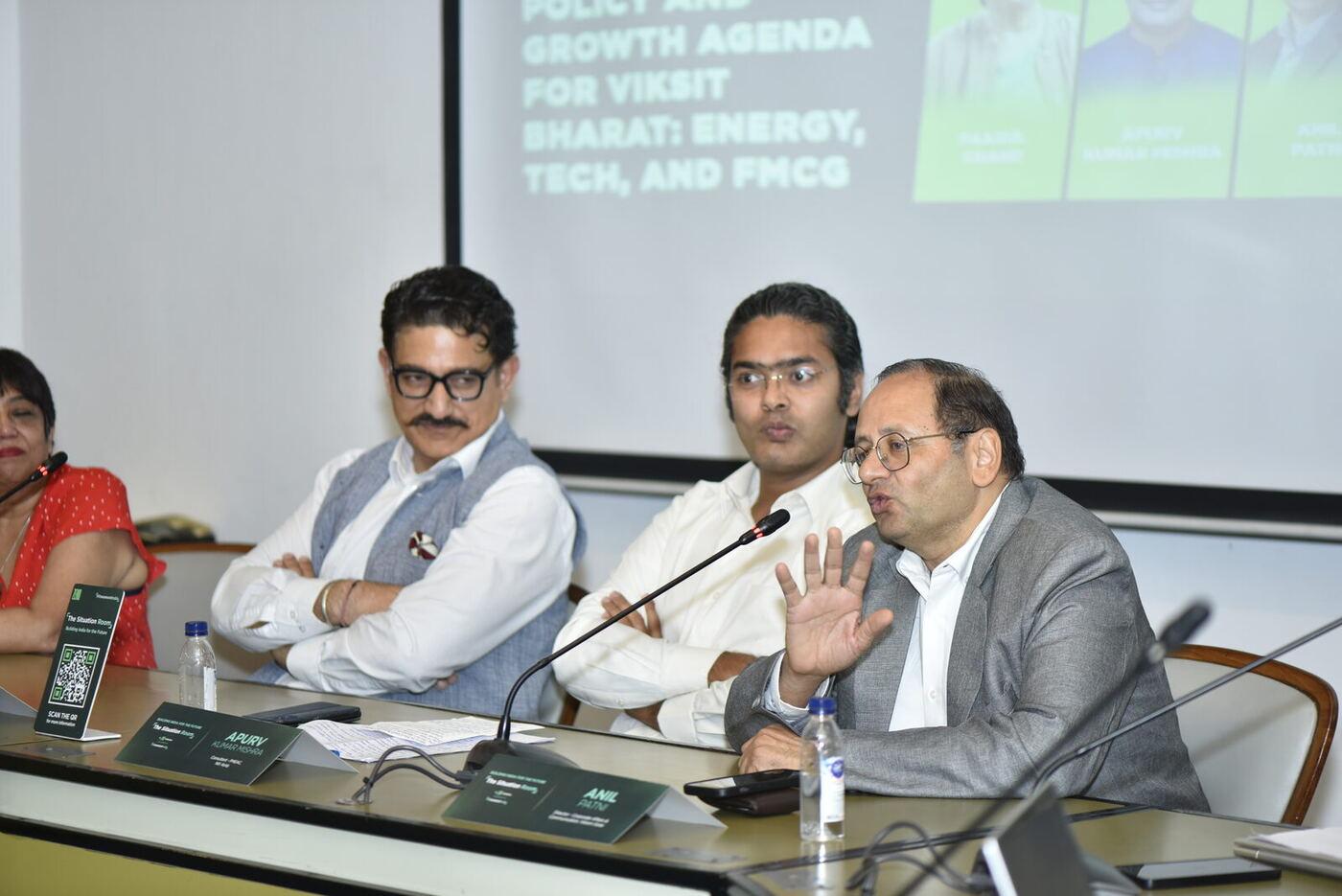 Anil Patni with palm raised mid-answer, co-panellist arms folded, title slide above